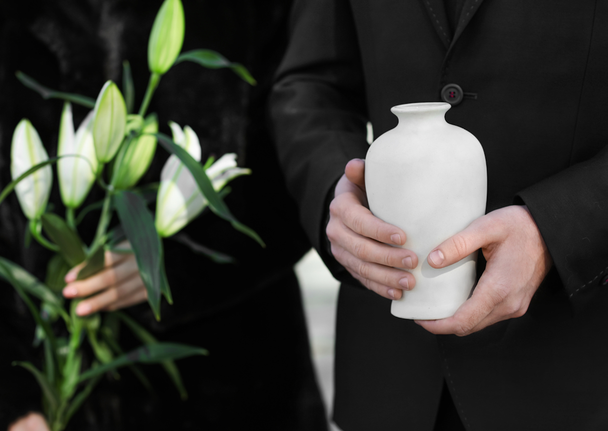 person in suit holding urn